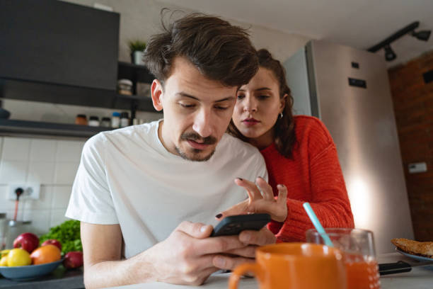istock Pensive girlfriend reading her boyfriend messages on mobile phone, while suspect of dishonesty 1370480821