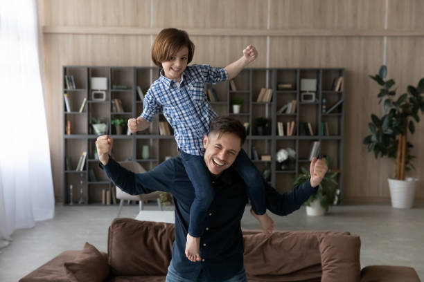 istock Smiling little son sitting on strong happy father shoulders 1370480862
