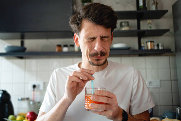 Man making the face after he tasted the juice Caucaisan young face grimacing after he tasted the juice sour taste stock pictures, royalty-free photos & images
