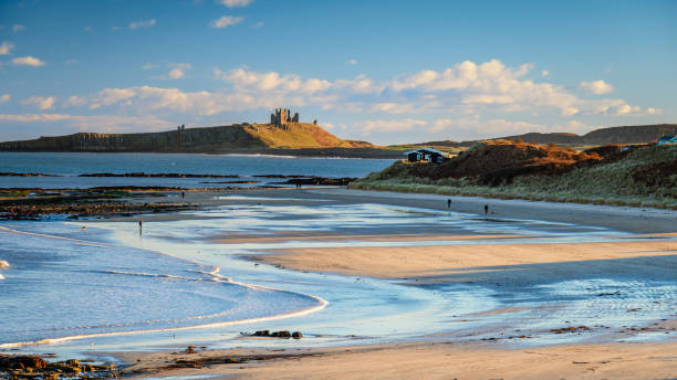 Low Newton Beach and Dunstanburgh Castle Part of the coastal section on the Northumberland 250, a scenic road trip though Northumberland with many places of interest along the route northumberland stock pictures, royalty-free photos & images