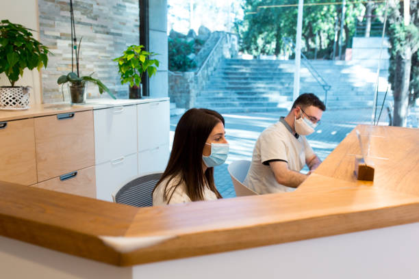 istock Two receptionists wearing face mask masks in physiotherapy centre 1370484894