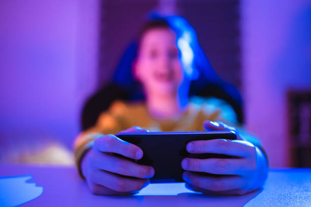istock Boy playing videogame on smartphone in the evening at home 1370485731