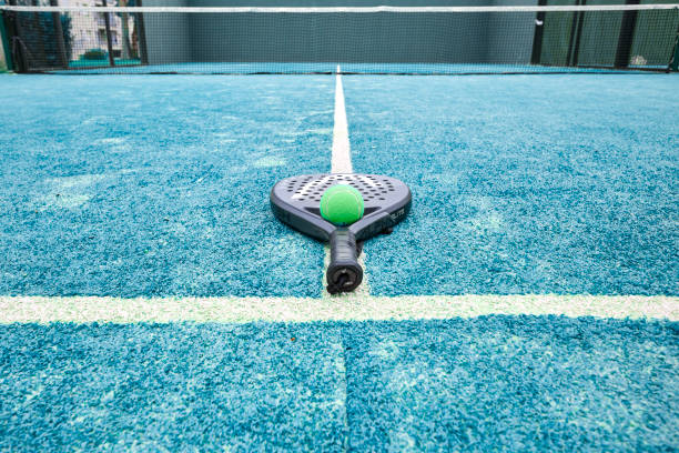 paddle tennis racket and balls on the blue professional court line