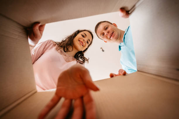 istock Couple Unpacking Cardboard Box Together 1370487223