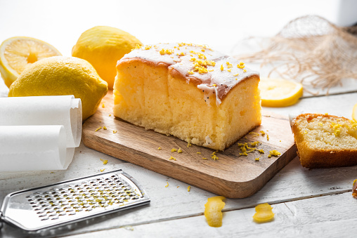 Several slices of lemon cake, lemon sponge cake, homemade, with sugar, flour, honey, yeast and lemons, dessert or for breakfast, on a wooden background.