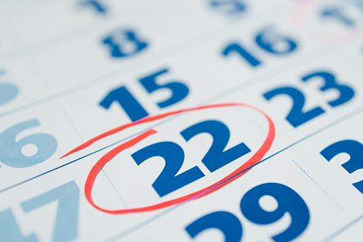 Marking the seventeenth 22 day of a month in the calendar with a red marker. Note of the calendar, significant date. Signing the day on the calendar. Reminder mark on the eighteenth 22 day of month.