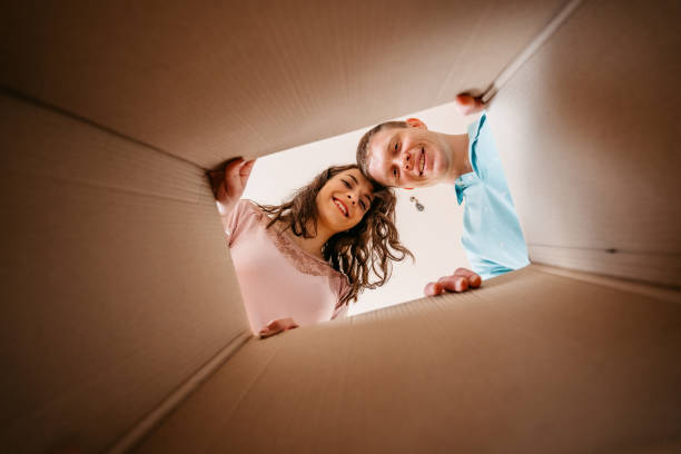 istock Couple Unpacking Cardboard Box Together 1370487512