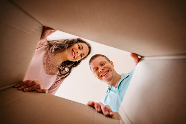 istock Couple Unpacking Cardboard Box Together 1370487665