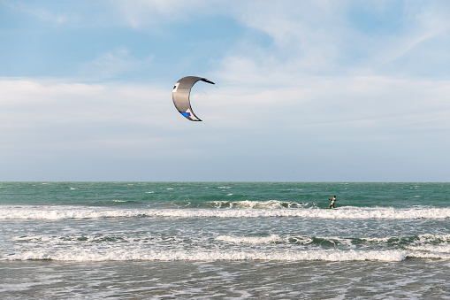 A man doing kite surfing on the beach