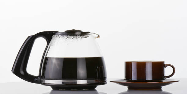 ハーフフルコーヒーポットと茶色のカップを白の上に - cup coffee pot coffee coffee cup ストックフォトと画像