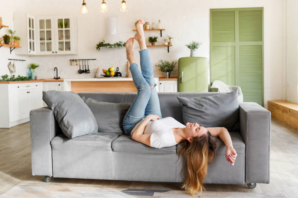 istock Young attractive woman relaxing on sofa at home 1370495835