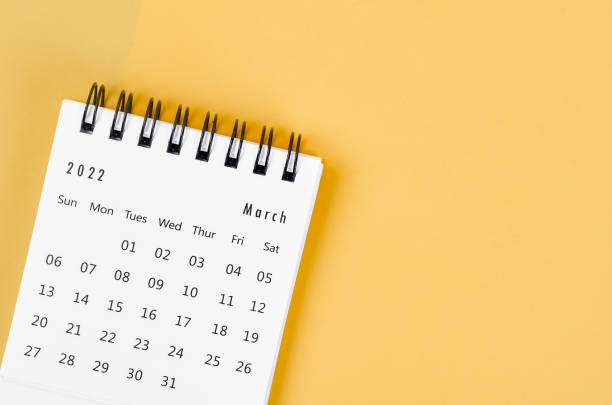 istock March 2022 desk calendar on light yellow background. 1370496058