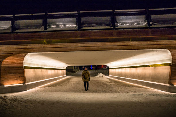 Sundsvall, Sweden A man in the evening light in a snowy downtown in winter in a passage.