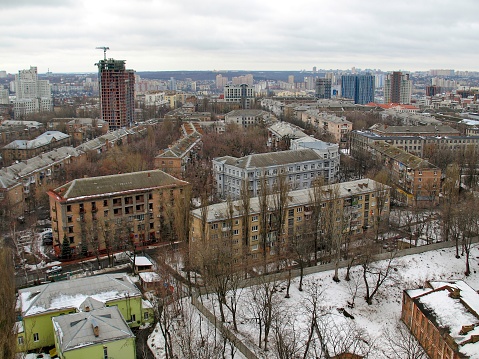 Snow starts to melt by late-February in Kyiv, Ukraine and has disappeared from the rooftops. The only remaining building still with snow is abandoned (bottom right).  This image was taken in the morning from a high rise apartment building in Pecherska looking towards the west.