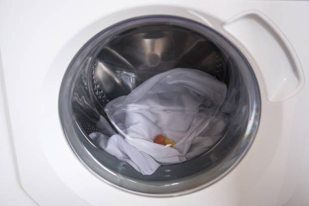 istock Washing machine with laundry and laundry capsule. Washing clothers 1370505714