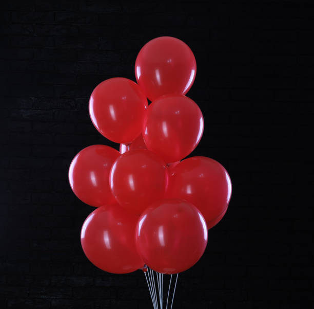 istock red balloons on black brick wall background 1370507337