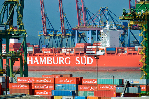 Santos, São Paulo - Brazil - December 15, 2013: Port of Santos, Cranes at container terminal 37. Partial view of the Hambur Sud cargo ship.