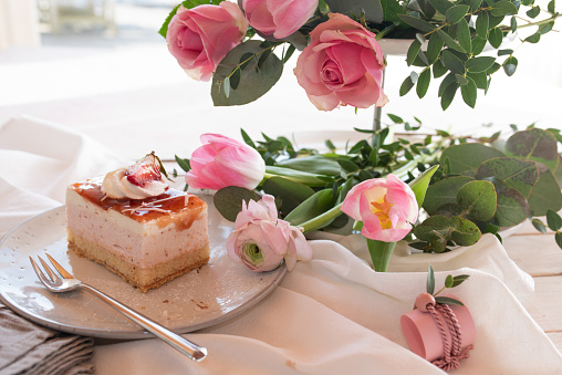 Coffee with cake and pink spring flowers for mother's day. Bright background with short depth of field and space for text.