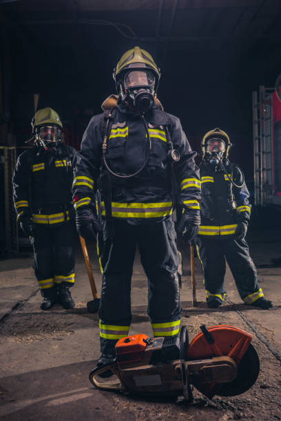 istock Group of three young fireman posing inside the fire department with uniform and tools 1370509643