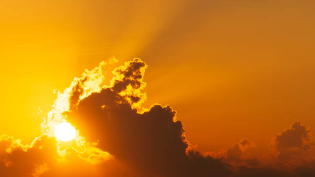 istock orange sky with sun shining behind clouds at morning, nature background 1370510078