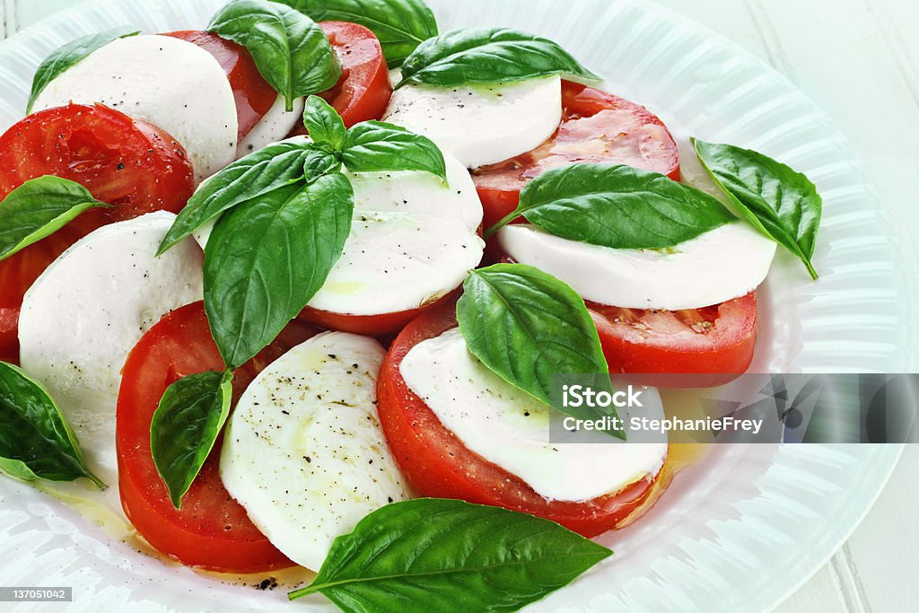 Fresh Caprese salad on a white plate Delicious fresh Caprese Salad on a white dish. Caprese Salad Stock Photo