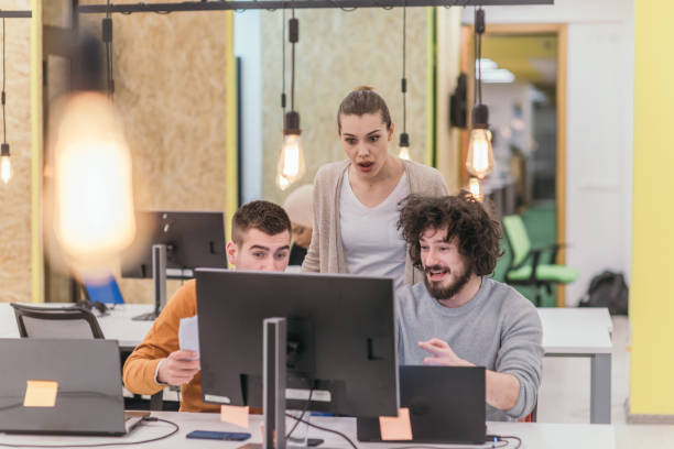 group of coworkers, colleagues having fun at the office while chatting and having fun. - cheering business three people teamwork imagens e fotografias de stock