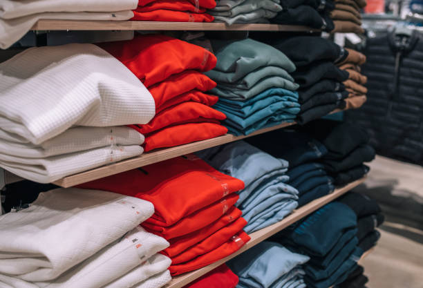 istock Folded clothes kept on shelves in shop. 1370510885