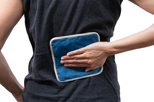 woman putting an ice pack on her back pain on white background, healthy concept