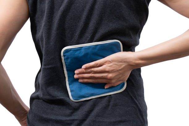 woman putting an ice pack on her back pain on white background, healthy concept woman putting an ice pack on her back pain on white background, healthy concept ice pack photos stock pictures, royalty-free photos & images