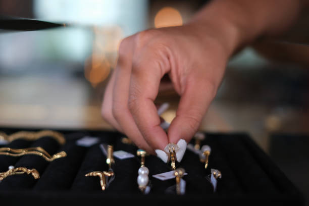 Close-up shot of an unrecognizable female hand choosing a beautiful ring to buy at a jewelry store.
