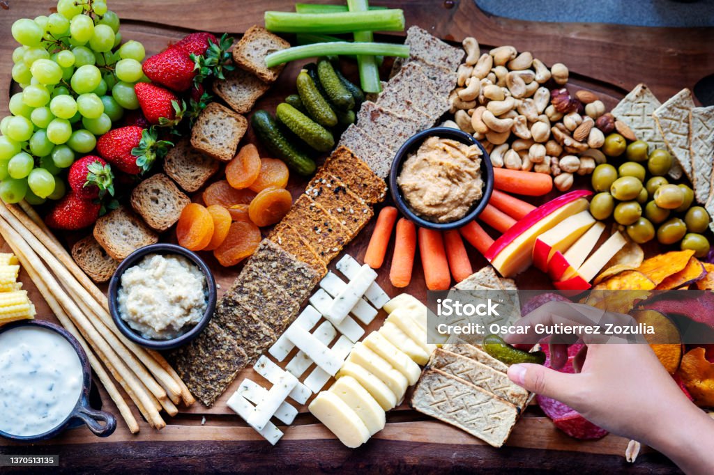 cutting board with gourmet food, fruits, vegetables and cheese Snack Stock Photo