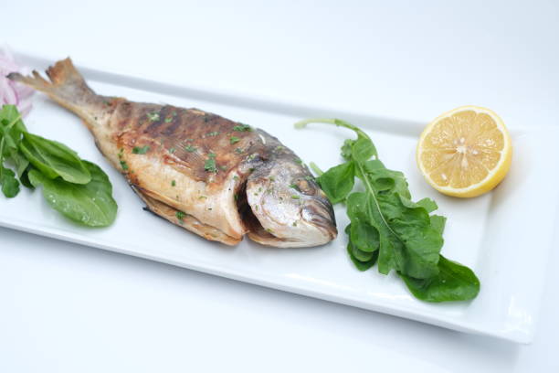 istock Sea bream with lemon and arugula top view 1370513957