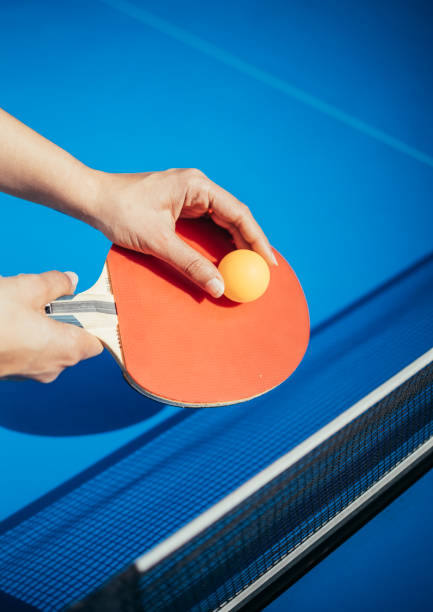 istock A woman's hand holding a table tennis racket next to the net 1370514719