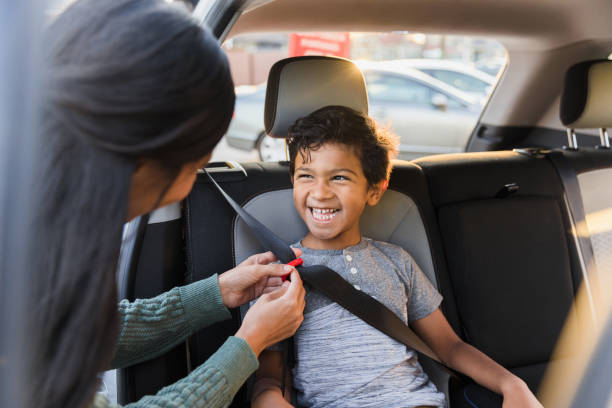 istock Unrecognizable mother adjusts seat belt for young son 1370517318