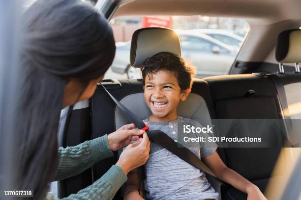 Unrecognizable Mother Adjusts Seat Belt For Young Son Stock Photo - Download Image Now