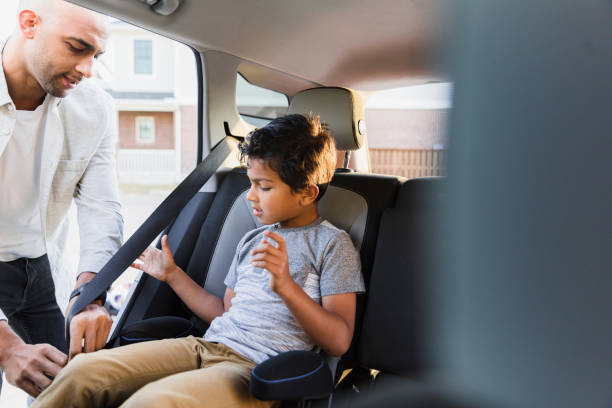 istock Mid adult father helps elementary age son with seat belt 1370517323