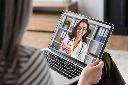 Senior old elderly pensioner woman grandmother having videocall conversation meeting virtual conference with a doctor telling about health problems on laptop remotely, telemedicine concept