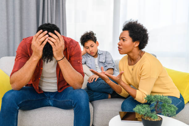 les parents se disputent pendant que le fils est assis entre eux à la maison. - disgust women african ethnicity human face photos et images de collection