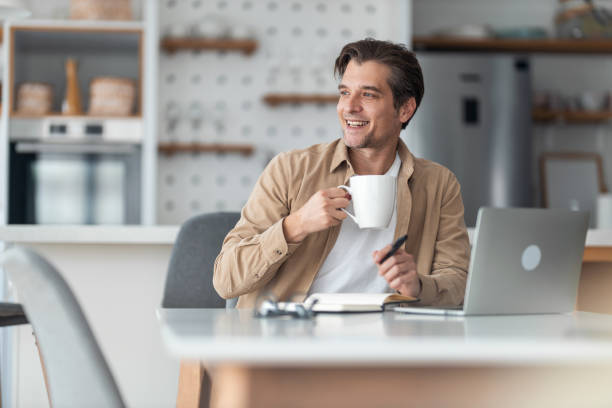 istock Happy freelancer day dreaming while drinking coffee at home office. 1370520443