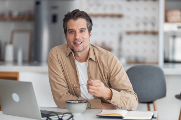 istock Happy entrepreneur eating breakfast while working on laptop from home. 1370520967