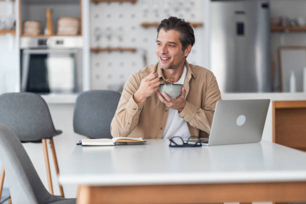 istock Happy man day dreaming during breakfast in dining room. 1370520971