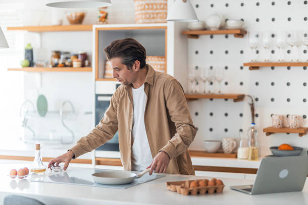 istock Mid adult man preparing breakfast in the kitchen. 1370521056