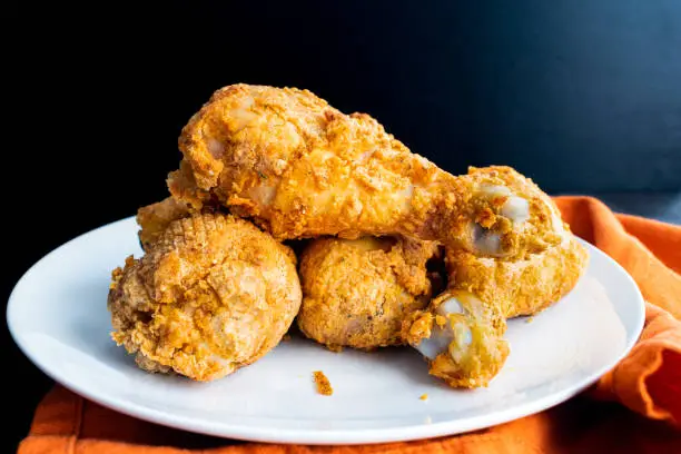 Side view of a plate of breaded and air fried chicken legs