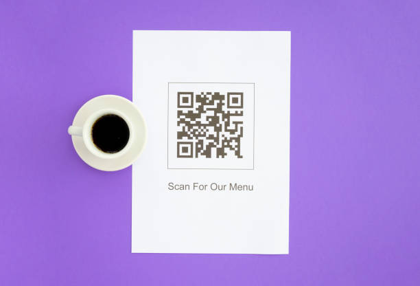 istock QR code for online menu service at table in restaurant. New contactless technology lifestyle protection coronavirus pandemic in restaurant. Flat lay, purple background 1370523220
