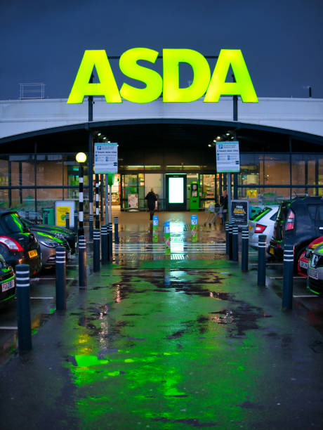 The car park and frontage of the a store of the ASDA British supermarket chain, located in a residential area in the North of England. Taken in portrait in late afternoon after rain. The car park and frontage of the a store of the ASDA British supermarket chain, located in a residential area in the North of England. Taken in portrait in late afternoon after rain. asda photos stock pictures, royalty-free photos & images