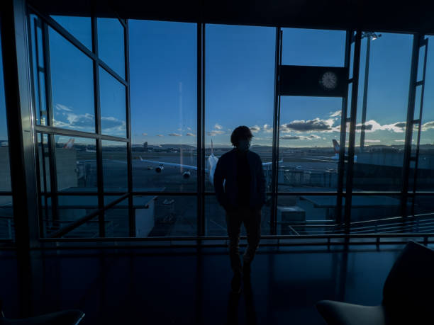 istock Man standing at airport terminal waiting to board flight 1370524180