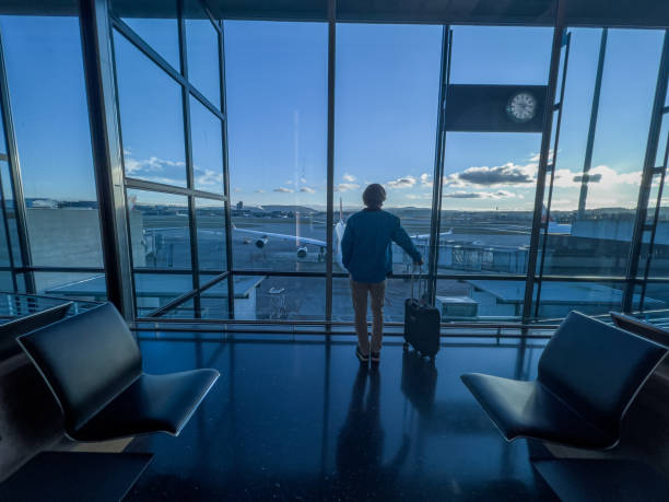 istock Man standing at airport terminal waiting to board flight 1370524236