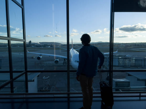 istock Man standing at airport terminal waiting to board flight 1370524354