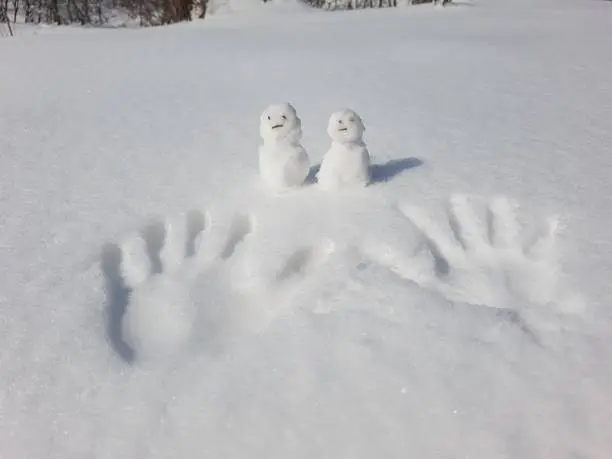 A male and female human pair made of snow with male and female handprints on them