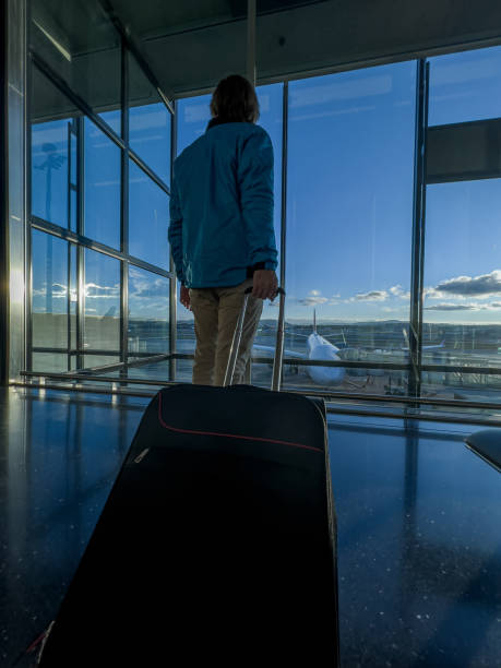 istock Man at the airport pulling his luggage at the gate 1370524885